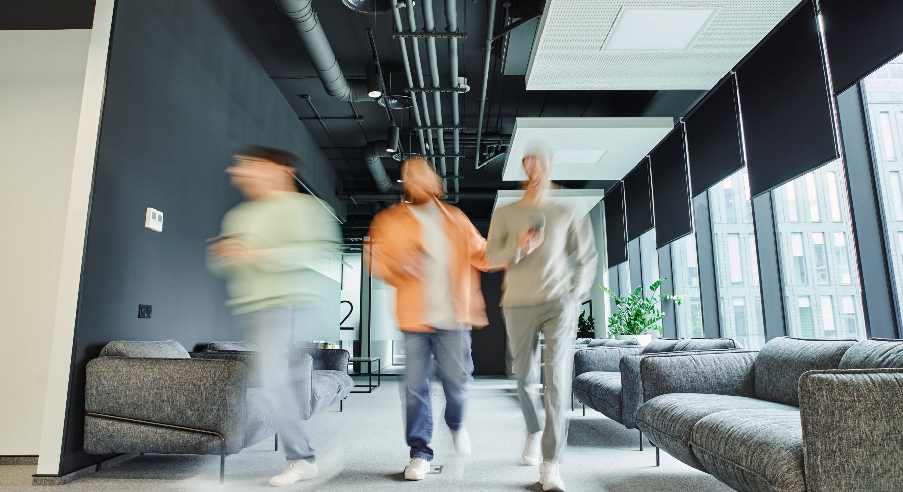 Group of people standing outdoors and one person has raised a hand to show number five with fingers