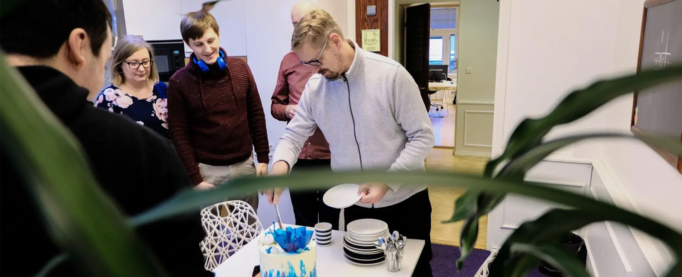 Mearra people around a Drupal-themed cake at Mearra Helsinki office's kitchen.