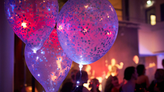 Event hall with three balloons in purple light