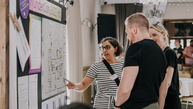Oksan is pointing a map on the wall