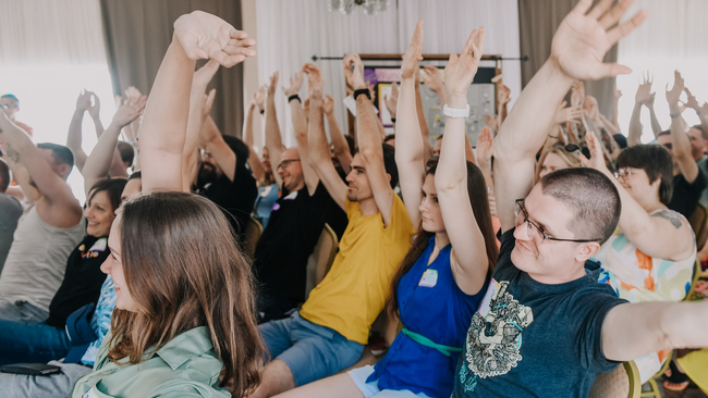 Audience raising both hands and smiling.