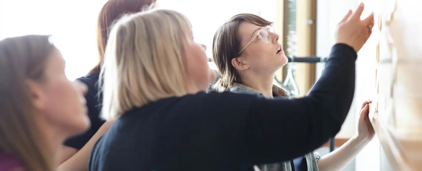 People co-working on a whiteboard
