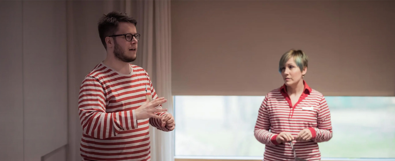 Otso speaking to auditorium, Kati listening