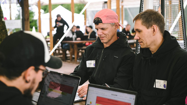 Tormi and Artis are looking at the screen