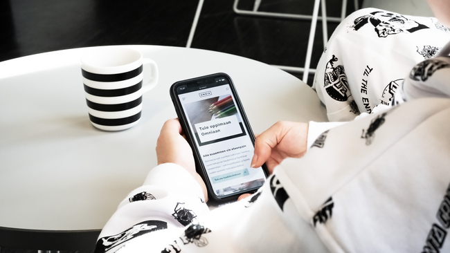 Person browsing Omnia.fi with a mobile device.