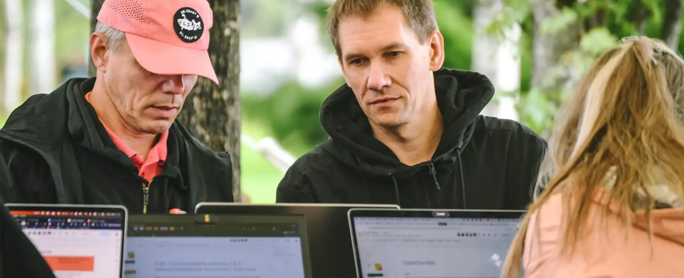 Two persons monitoring  on laptop screens
