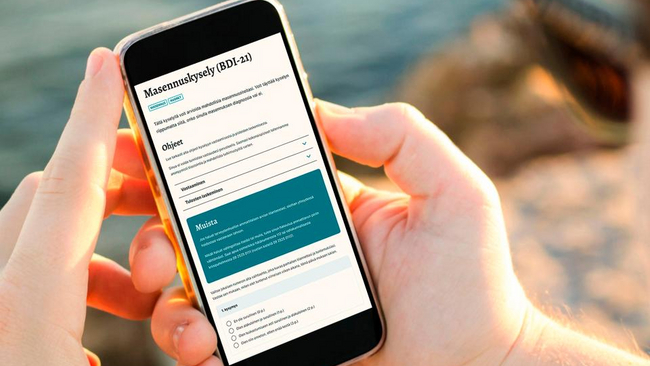 A person holding a phone with the mielenterveystalo.fi open on screen