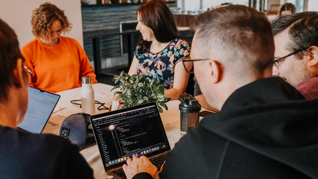 People working together around a table with their laptops