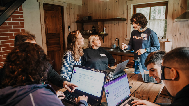 A person giving instructions to people working around a table